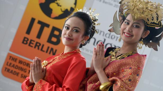 epa03591622 Two Indonesian woman pose in front of a placard advertising the world&#039;s largest tourism fair ITB Berlin during a press conference in Berlin, Germany, 20 February 2013. Indonesia is this year&#039;s host country at the ITB, which takes place from 06 to 10 March 2013. EPA/RAINER JENSEN