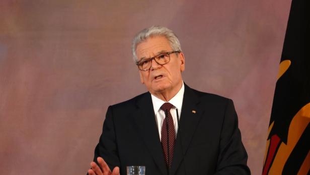 Walter Steinmeier hält eine Rede vor der Deutschlandflagge.