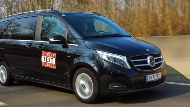 Ein schwarzer Mercedes-Benz Van fährt auf einer Autobahn.