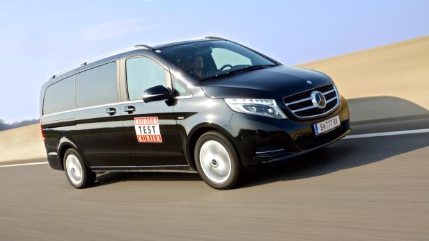 Ein schwarzer Mercedes-Benz Van fährt auf einer Autobahn.