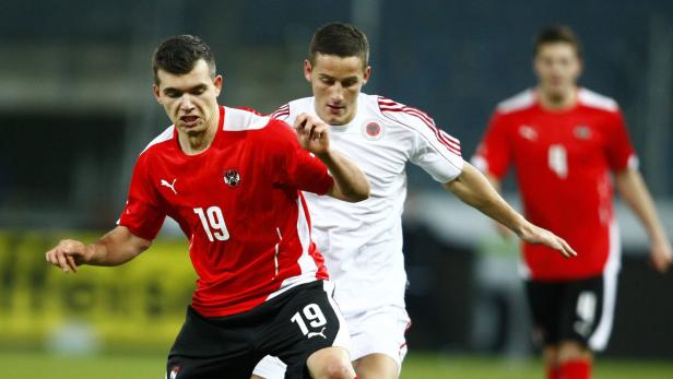 Zwei Fußballspieler im Zweikampf während eines Spiels.