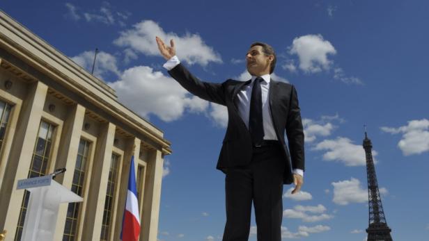 Nicolas Sarkozy gestikuliert vor dem Trocadéro in Paris mit dem Eiffelturm im Hintergrund.