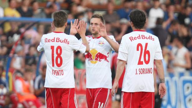 Drei Fußballspieler der Red Bulls feiern auf dem Spielfeld.