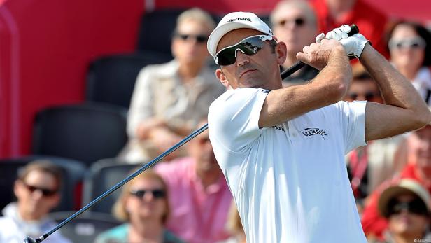 Ein Golfspieler schwingt seinen Schläger vor einer Zuschauermenge.