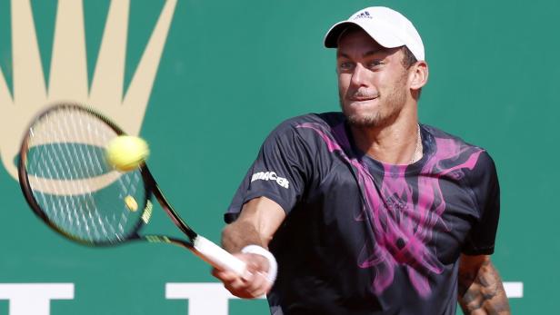 Ein Tennisspieler schlägt einen gelben Tennisball mit seinem Schläger.