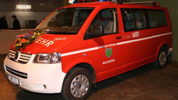 Ein rotes Feuerwehrfahrzeug der Freiwilligen Feuerwehr Waldstein mit Blumenschmuck.