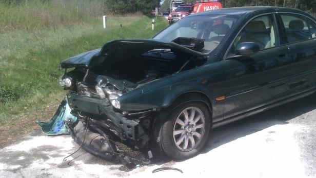 Ein dunkelgrüner Jaguar mit schweren Frontschäden nach einem Unfall.