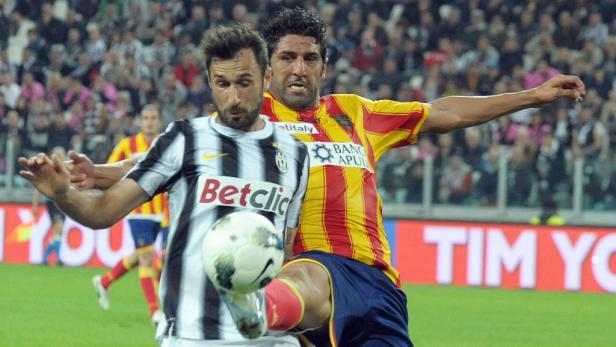 Zwei Fußballspieler kämpfen um den Ball während eines Spiels.