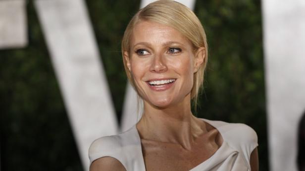 Gwyneth Paltrow lächelt in einem weißen Kleid.