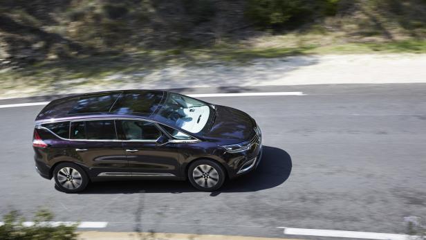 Ein dunkellila Renault Espace fährt auf einer Landstraße.