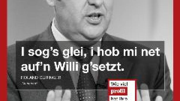 Ein Mann im Anzug gestikuliert mit den Händen vor einem roten Rahmen.