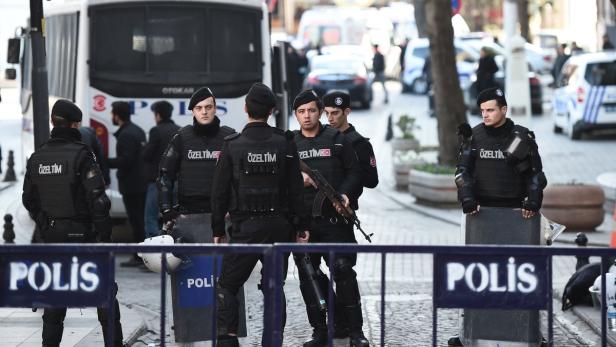 Türkische Polizisten in Kampfmontur stehen hinter einer Absperrung.