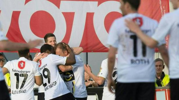 Fußballspieler von Fohrenburger feiern gemeinsam auf dem Spielfeld.