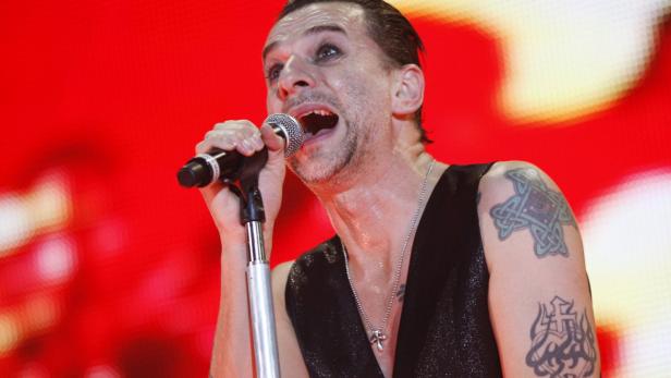 David Gahan von Depeche Mode singt mit Tätowierungen auf der Bühne.