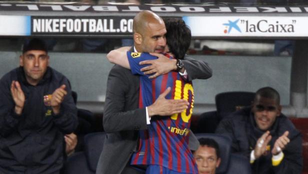 Pep Guardiola umarmt einen Spieler des FC Barcelona.