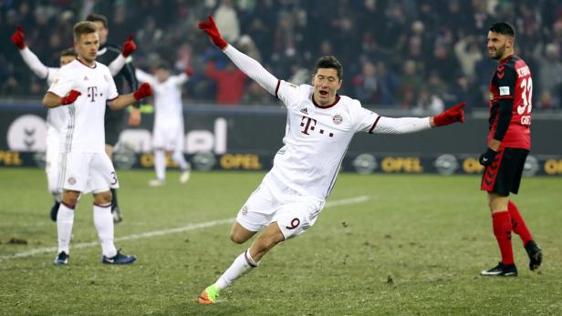 Robert Lewandowski jubelt mit ausgestreckten Armen auf dem Fußballfeld.