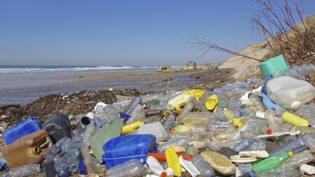 Ein Strand ist mit Plastikmüll übersät.