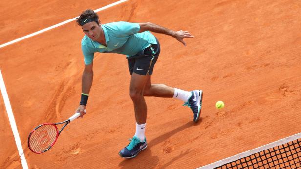 Roger Federer spielt Tennis auf einem Sandplatz.