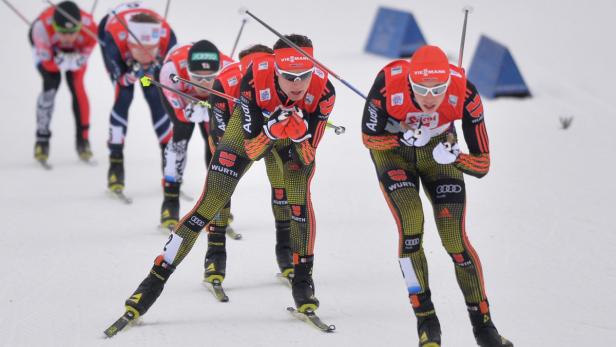 Mehrere Langläufer in Sportkleidung nehmen an einem Rennen teil.