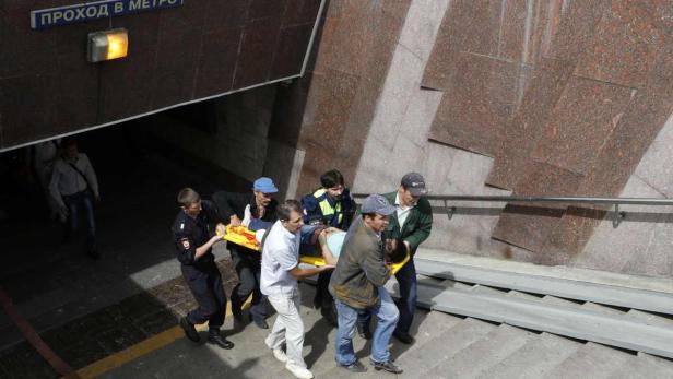 Members of the emergency services carry an injured Verletzte werden den U-Bahnaufgang hinaufgebracht.