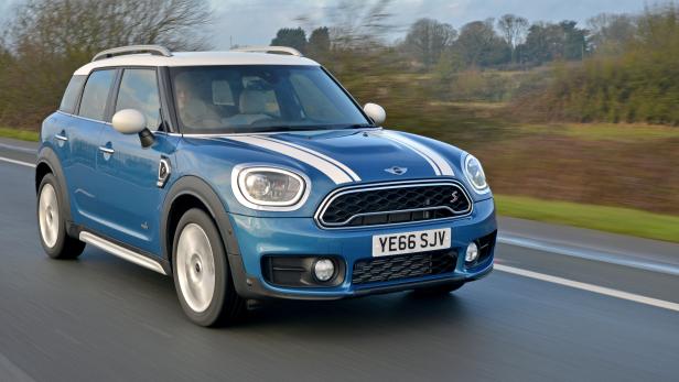 Ein blauer Mini Countryman fährt auf einer Landstraße.