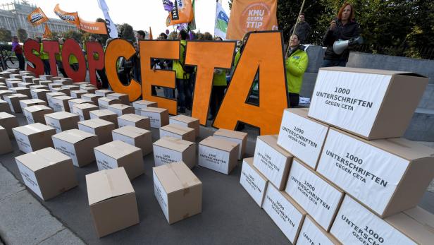 STOP in roten und CETA in orangen Großbuchstaben und viele Kartons auf den schwarz auf weiß steht 1000 Unterschriften gegen CETA