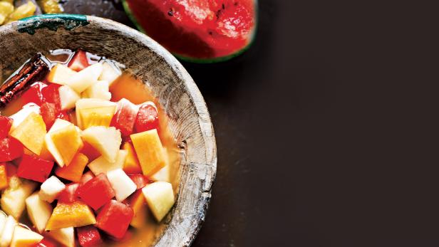 Ein Holzteller gefüllt mit mexikanischem Obstpunsch, auch bekannt als Ponche de Frutas.