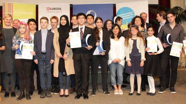 Eine Gruppe Jugendlicher steht mit Urkunden und Preisen auf einer Bühne.