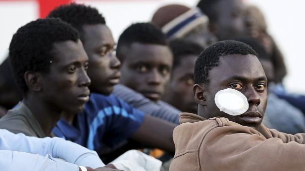 Migrants rest after they disembarked in the Sicili