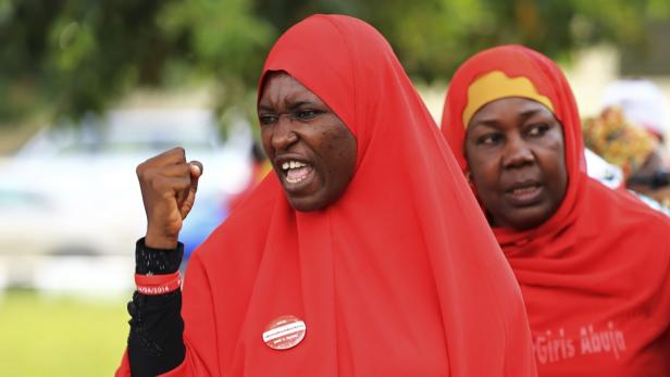 Eine Frau mit rotem Kopftuch und erhobener Faust demonstriert für „Bring Back Our Girls“.