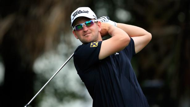 Ein Mann mit Sonnenbrille schwingt einen Golfschläger.