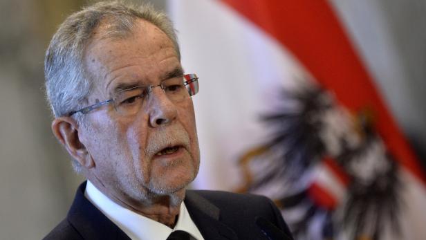 Alexander Van der Bellen bei einer Rede vor der österreichischen Flagge.