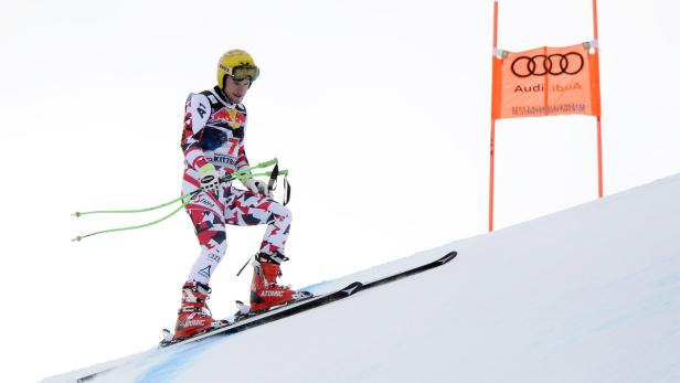 Ein Skirennläufer steht auf der Piste mit einem Audi-Banner im Hintergrund.