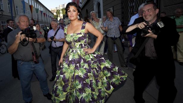 Anna Netrebko posiert in einem Kleid mit Auberginenmuster für Fotografen.