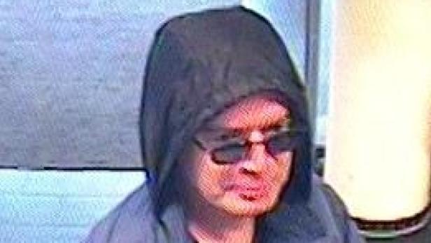 Eine Person mit Kapuze und Sonnenbrille blickt in die Kamera.