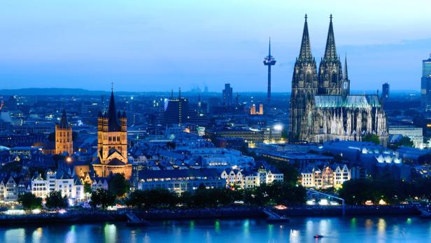 Die Kölner Skyline mit dem Dom und dem Fernsehturm bei Dämmerung.