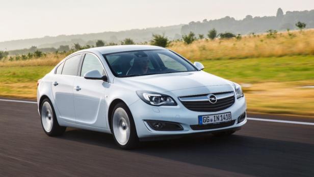Ein weißer Opel Insignia fährt auf einer Landstraße.