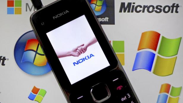 Ein Nokia-Handy vor einem Hintergrund mit Microsoft- und Windows-Logos.