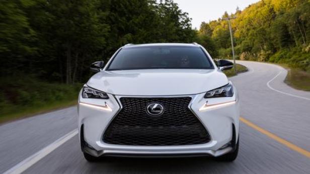 Ein weißer Lexus fährt auf einer kurvenreichen Straße.