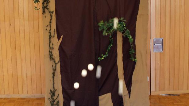 Eine improvisierte Bühne mit fallenden weißen Bällen im Innenraum.