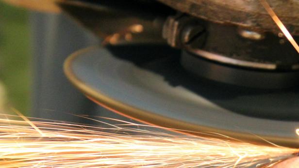 Ein Winkelschleifer erzeugt Funken beim Schleifen von Metall.