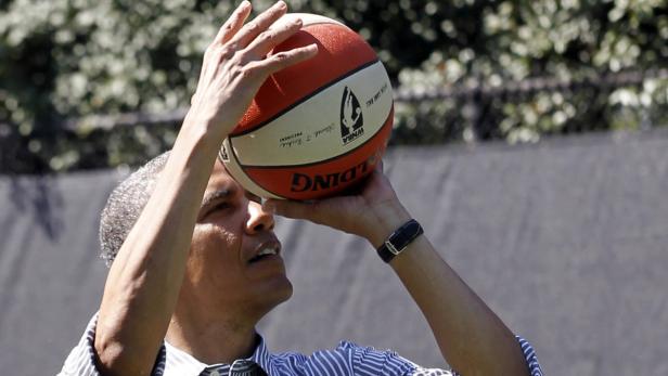 Barack Obama wirft einen WNBA-Basketball.