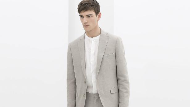 Ein Mann trägt einen hellen Anzug und ein weißes Hemd.