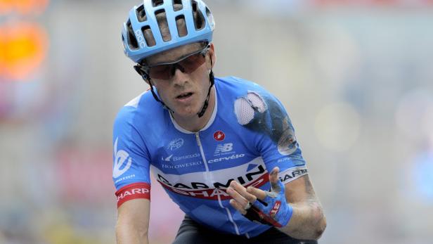 Ein Radrennfahrer mit blauem Trikot und Helm während eines Rennens.