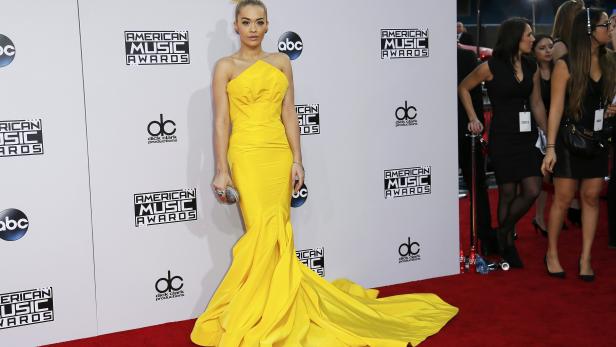 Rita Ora in einem gelben Kleid auf dem roten Teppich der American Music Awards.