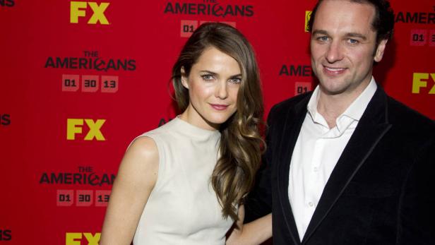 Keri Russell und Matthew Rhys posieren vor einer Wand für die Fernsehserie „The Americans“.