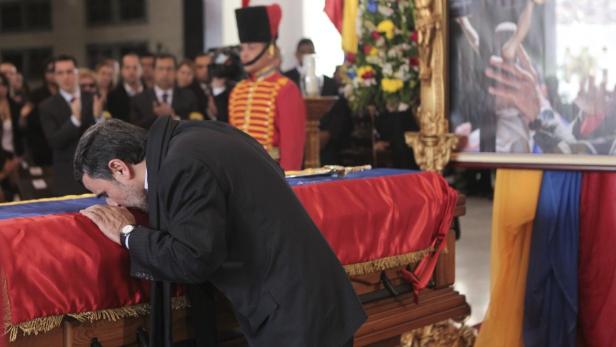 Iran&#039;s President Mahmoud Ahmadinejad pays tribute to late Venezuelan President Hugo Chavez, during the funeral service at the Military Academy in Caracas March 8, 2013, in this picture provided by the Miraflores Palace. Chavez will be embalmed and put on display &quot;for eternity&quot; at a military museum after a state funeral and an extended period of lying in state, acting President Nicolas Maduro said on Thursday. REUTERS/Miraflores Palace/Handout (VENEZUELA - Tags: POLITICS OBITUARY TPX IMAGES OF THE DAY) ATTENTION EDITORS - THIS IMAGE HAS BEEN SUPPLIED BY A THIRD PARTY. IT IS DISTRIBUTED, EXACTLY AS RECEIVED BY REUTERS, AS A SERVICE TO CLIENTS. FOR EDITORIAL USE ONLY. NOT FOR SALE FOR MARKETING OR ADVERTISING CAMPAIGNS