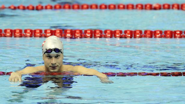 Ein Schwimmer mit Badekappe und Schwimmbrille im Schwimmbecken.