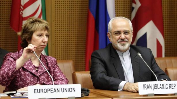 Catherine Ashton und Mohammad Javad Zarif bei einer Sitzung mit Flaggen im Hintergrund.