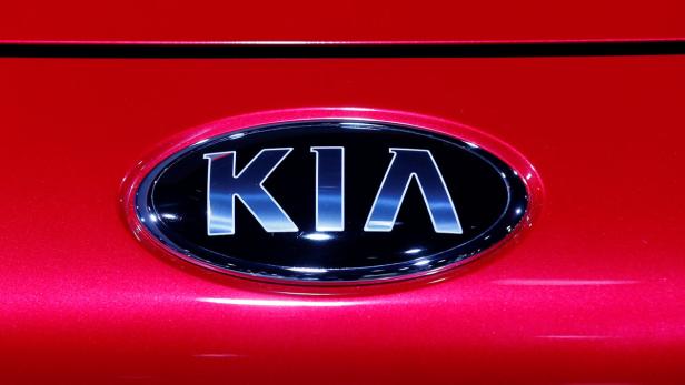 Das Kia-Logo auf der Rückseite eines roten Autos.